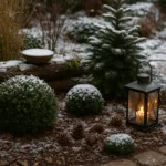 Winterdeko für Beete mit Laterne, Buchsbaum und Schnee im winterlichen Garten