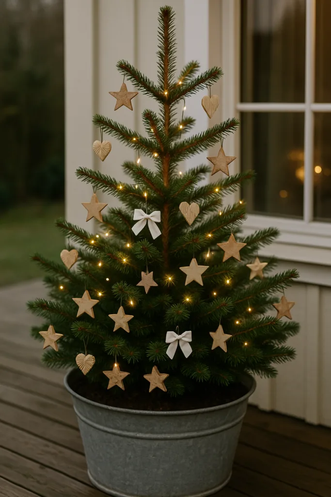 Weihnachtsdeko für die Terrasse - 6 Ideen, die echtes Weihnachts-Feeling bringen Kleiner Weihnachtsbaum mit Lichtern und Holzdeko als Weihnachtsdeko auf der Terrasse