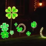 Beleuchtete Kleeblätter und Hufeisen als Silvesterdeko im Vorgarten bei Nacht