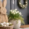 Moderne Osterdeko für die Haustür mit Holzhase, Pflanzen und natürlicher Frühlingsdeko im Eingangsbereich