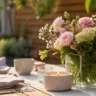 Moderne Muttertagsdeko im Garten mit Tisch, Blumen und Kerzen im natürlichen Licht