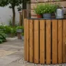 Regentonne DIY mit Holzverkleidung im Garten, dekorativ bepflanzt und natürlich integriert