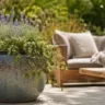 Gartendeko aus Keramik mit großem Pflanztopf auf sonniger Terrasse im Garten.