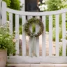 Gartentor Deko im Mai mit Kranz, Blumen und Pflanzkübeln im Garten