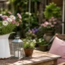 Schrebergarten Deko im Mai mit Holzsitzplatz, Blumen, Laterne und natürlicher Gartengestaltung