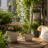 Kleiner Balkon Deko im Mai mit Blumen, Kräutern, Holzstuhl und gemütlicher Atmosphäre