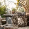 Gartendeko aus Naturmaterialien mit Weidenlaterne, Holz und Trockenpflanzen im Garten