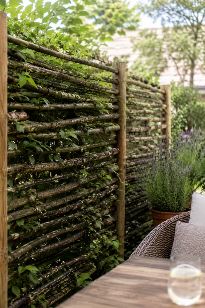 Gartendeko aus Ästen als natürlicher Sichtschutz mit gemütlicher Sitzecke im Garten