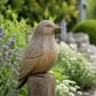 Gartendeko mit Holzfiguren entlang eines Gartenwegs zwischen Lavendel und blühenden Stauden.