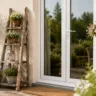 Terrassentürdeko im Juni mit Holzleiter, Sommerblumen und bepflanzter Terrassentür im Garten.