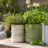 Gartendeko mit alten Konservendosen als Kräuterpflanzer auf rustikalem Holztisch im Garten.