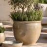 Terrassendeko mit Keramik auf einer sonnigen Terrasse mit großen Pflanzgefäßen, Lavendel und Rosmarin.
