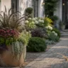 Vorgartendeko im August mit Pflanzkübel, Gartenweg, Gräsern und spätsommerlichen Blüten.