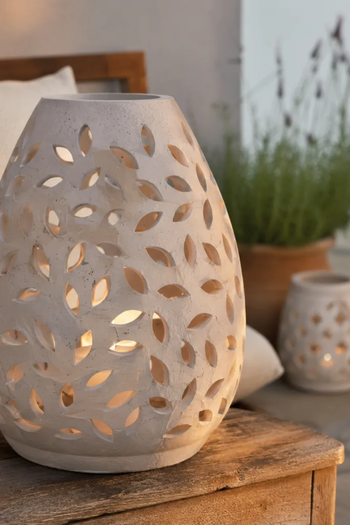 Diese 5 Keramik-Ideen lassen deine Terrasse hochwertiger wirken Terrassendeko mit Keramik: Große Keramiklaterne mit warmem Licht auf einem Holztisch.
