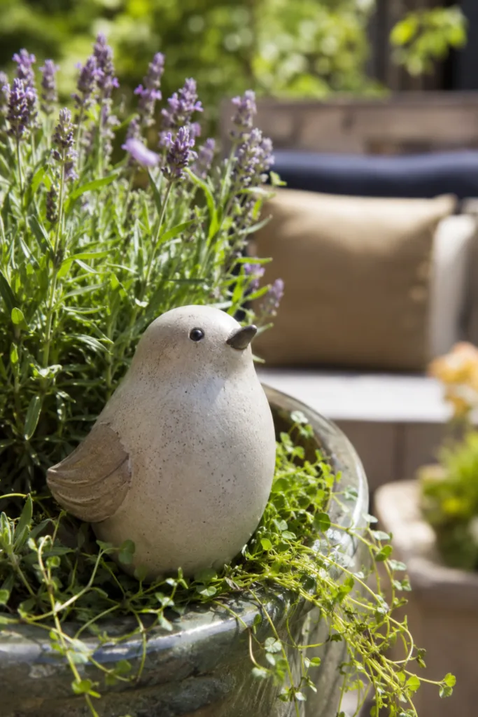 Diese 5 Keramik-Ideen lassen deine Terrasse hochwertiger wirken Terrassendeko mit Keramik: Helle Keramikfigur zwischen Lavendel und Grünpflanzen auf der Terrasse.