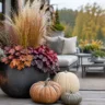 Moderne Herbstdeko für große Terrassen mit Pflanzkübel, Ziergräsern, Kürbissen und Laternen vor Lounge.