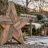 Weihnachtsdeko aus Holz für den Garten mit großem Holzstern im winterlichen Garten.