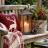 Weihnachtsdeko auf einer Holzbank mit kariertem Schneeflockenkissen, Laterne, Strickdecke und Tannenzweigen.