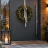 Weihnachtsdeko für die Haustür mit Tannenkranz, Girlande und winterlichen Pflanzkübeln.